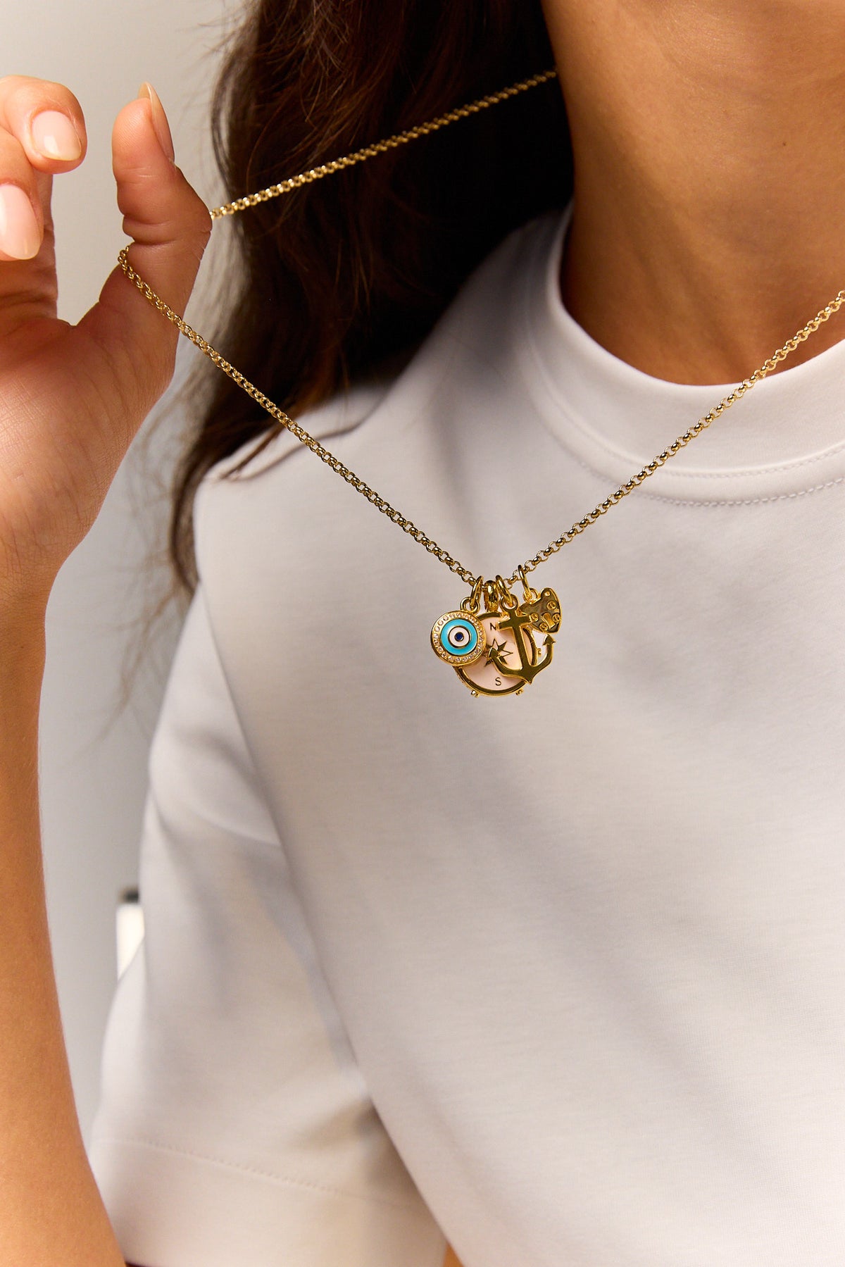 Gold-tone pendant necklace with blue evil-eye and anchor/star charms