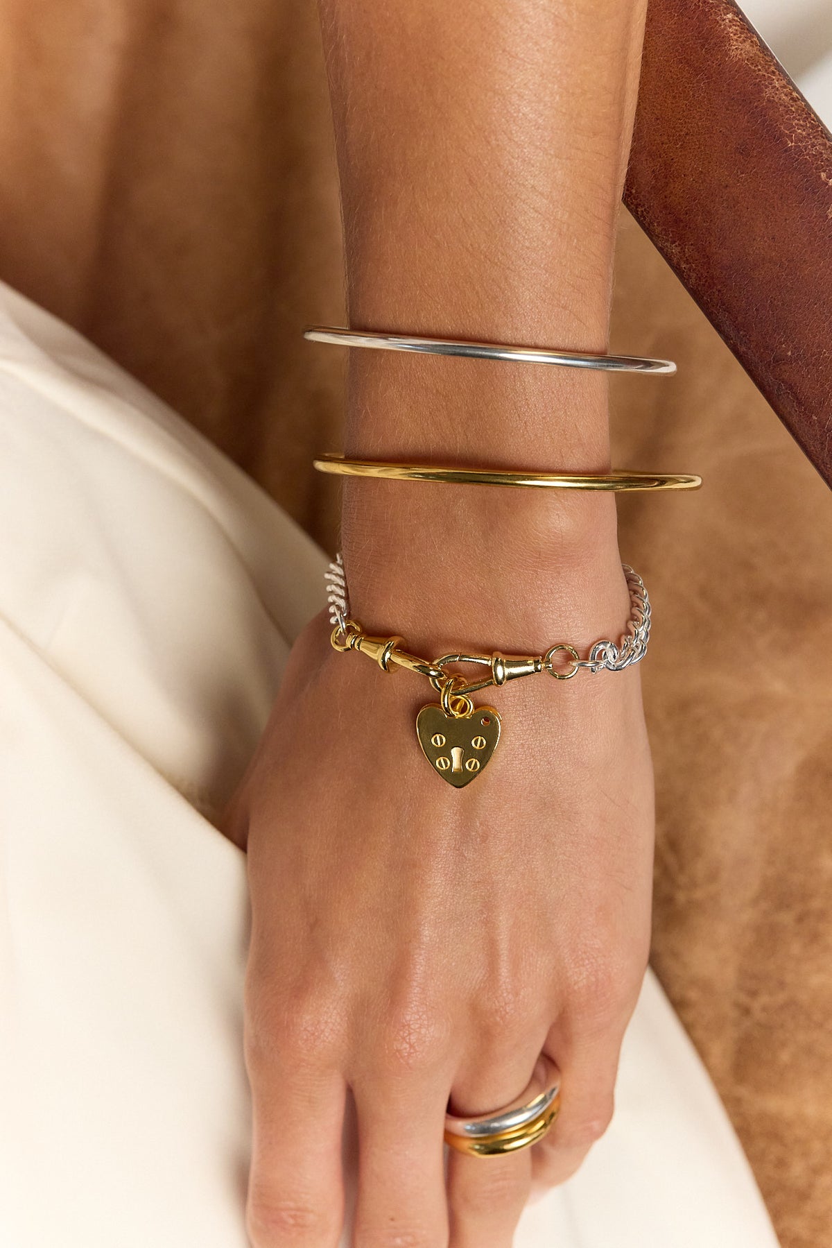 Gold heart padlock charm chain bracelet worn on wrist
